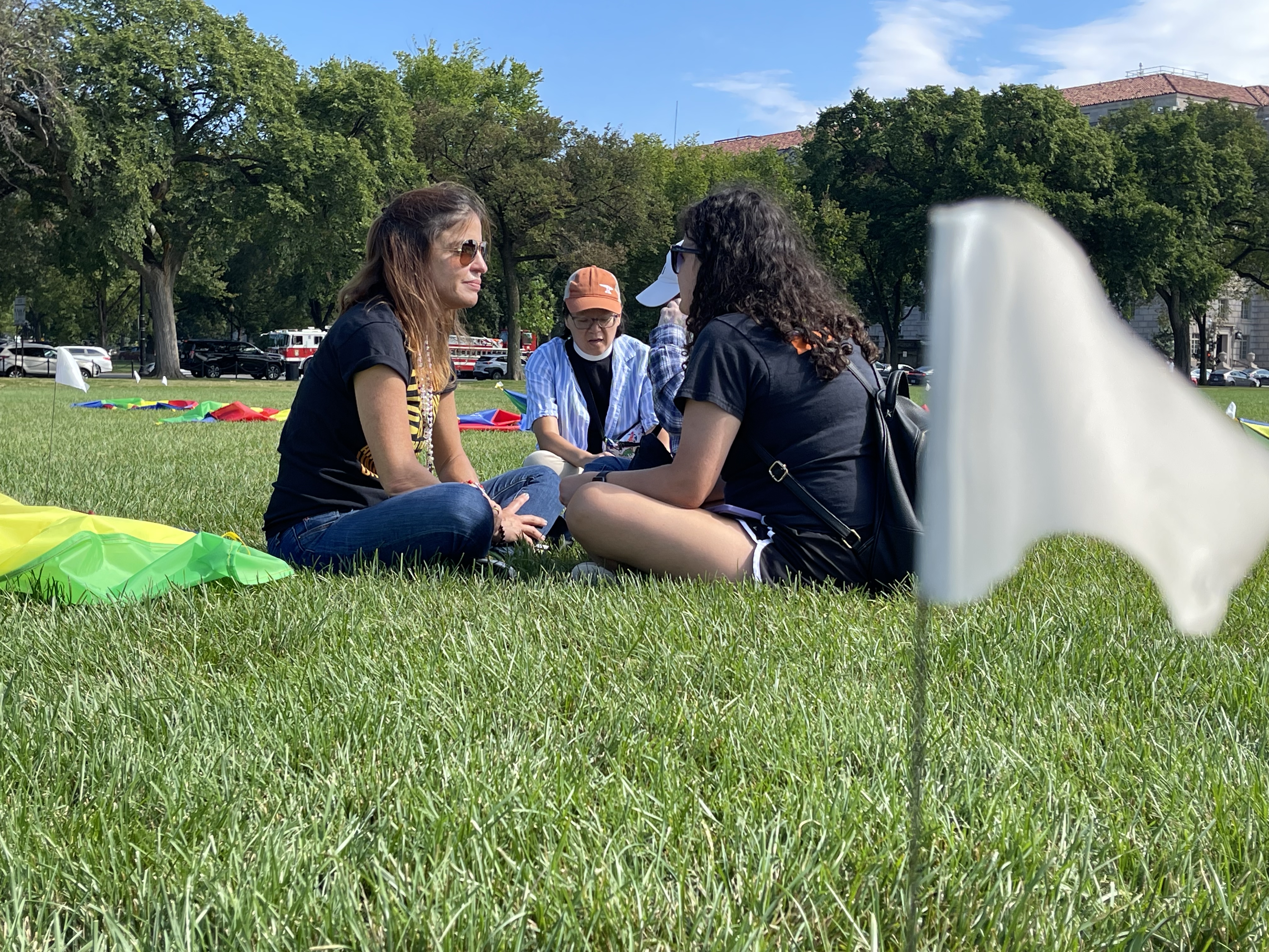 Patricia en el Washington Monument de DC, conversa con asistentes a la protesta, durante la cual desplegaron paracaídas de colores en las áreas verdes, en representación de los niños asesinados en tiroteos.